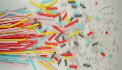 Multi-coloured straws in a bunch, chopped up and in microplastic particles