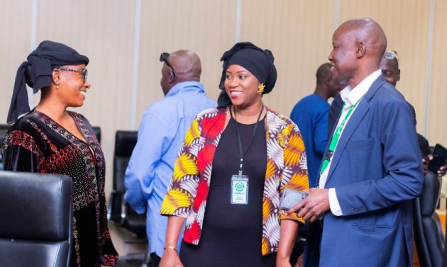 Three Gambians talking at a finance workshop on plastic pollution.