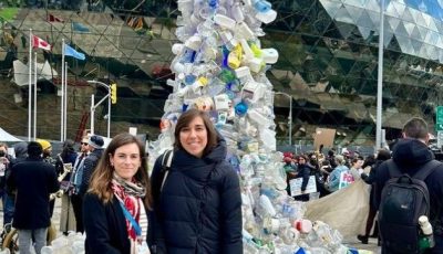 Two women standing in front of a torrent of plastic pollution - at artwork at the fourth round of treaty negotiations towards a global plastics treaty