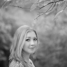 Profile photo of Emma Kai Thomas, Senior Communications Manager at Common Seas. Emma wears a striped jumper and smiles at the camera side-on. Photo is in greyscale.