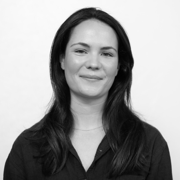 Profile photo of Zinnie Cowing, Senior Researcher at Common Seas. She is wearing a dark shirt and smiling at the camera. Photo is in gresycale