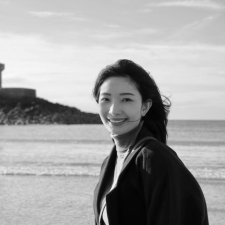 Profile photo of Jiawei Liu, School Engagement Officer at Common Seas. Jiawei is wearing a light-coloured turtle neck and a dark jacket, and smiling at the camera side-on. Photo is in greyscale.