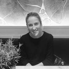 Profile photo of Marina Grissin, Education Officer, Greece. Marina is wearing a dark long-sleeved top and smiles at the camera. Photo is in greyscale.